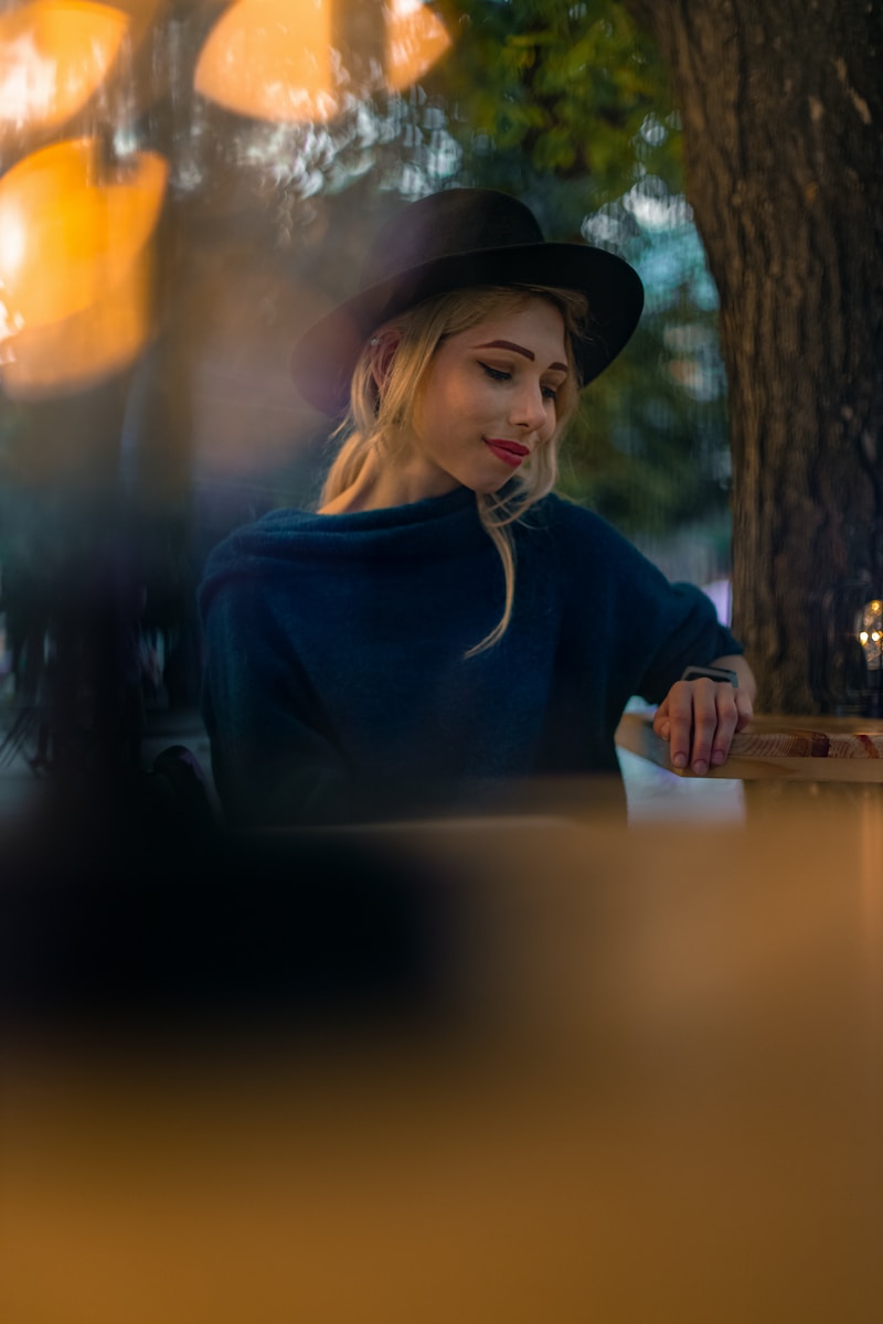 woman in black long sleeve shirt wearing black hat