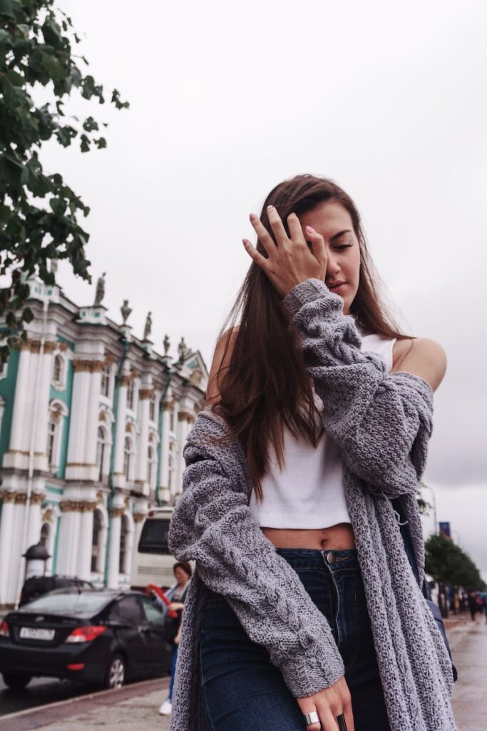 woman wiping her eye on the sidewalk