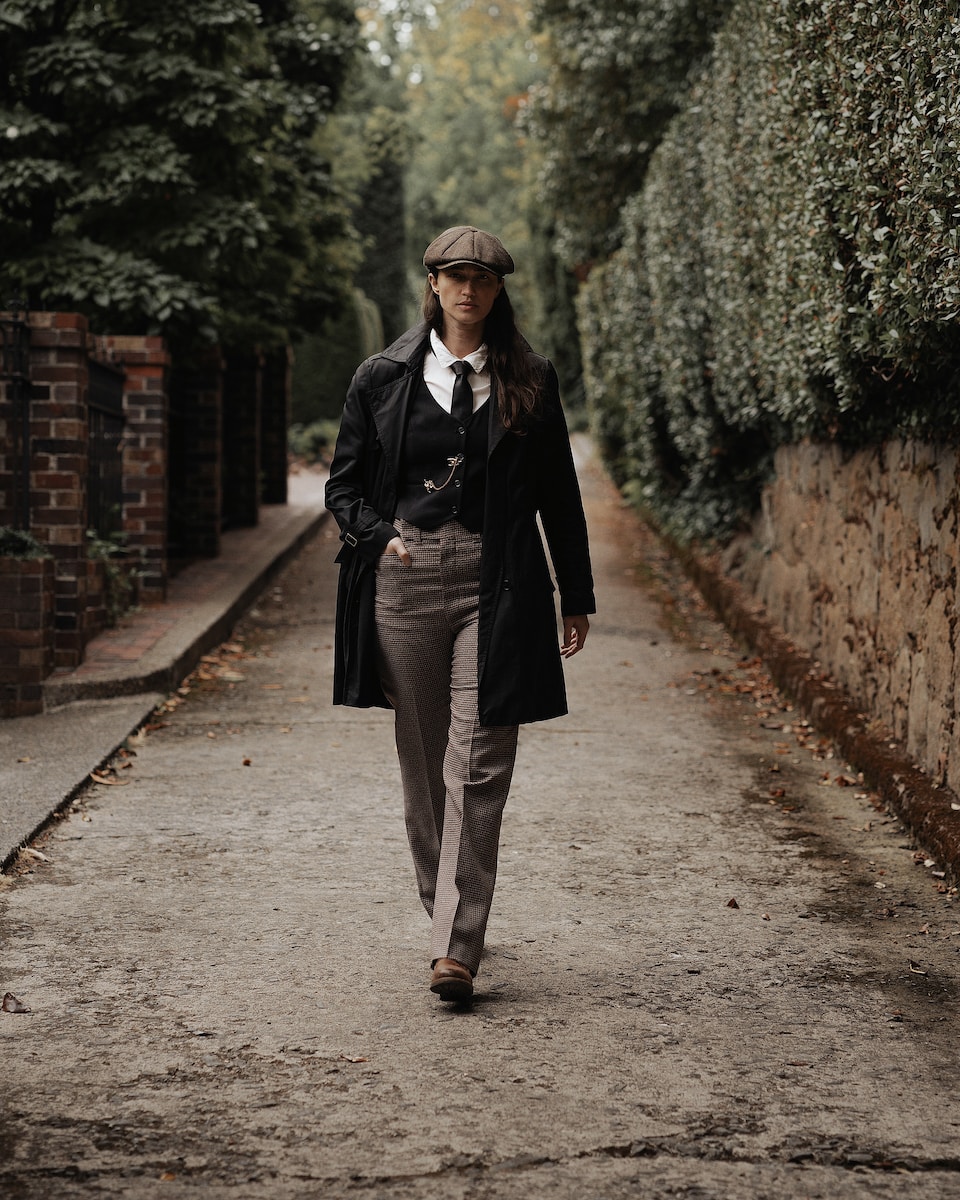 a woman walking down a street in a suit and tie