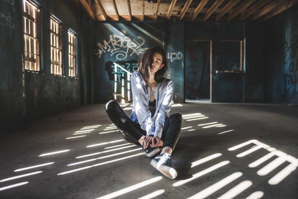 woman wearing blue jacket sitting on floor