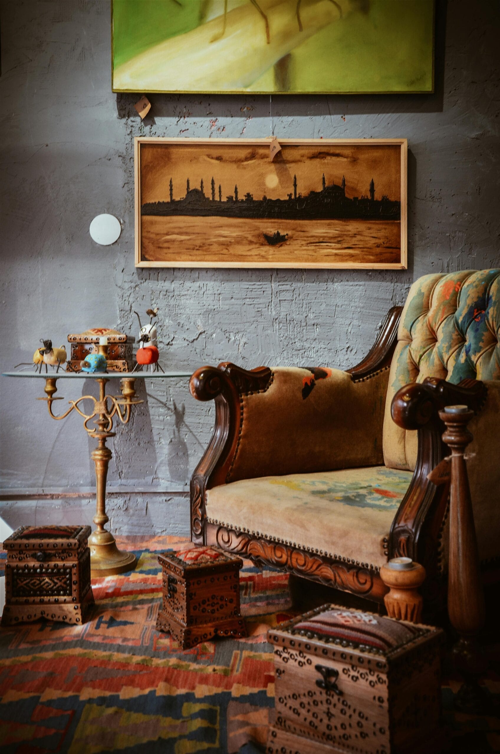 Cozy living room with a vintage armchair, artistic wall art, and wooden decor.