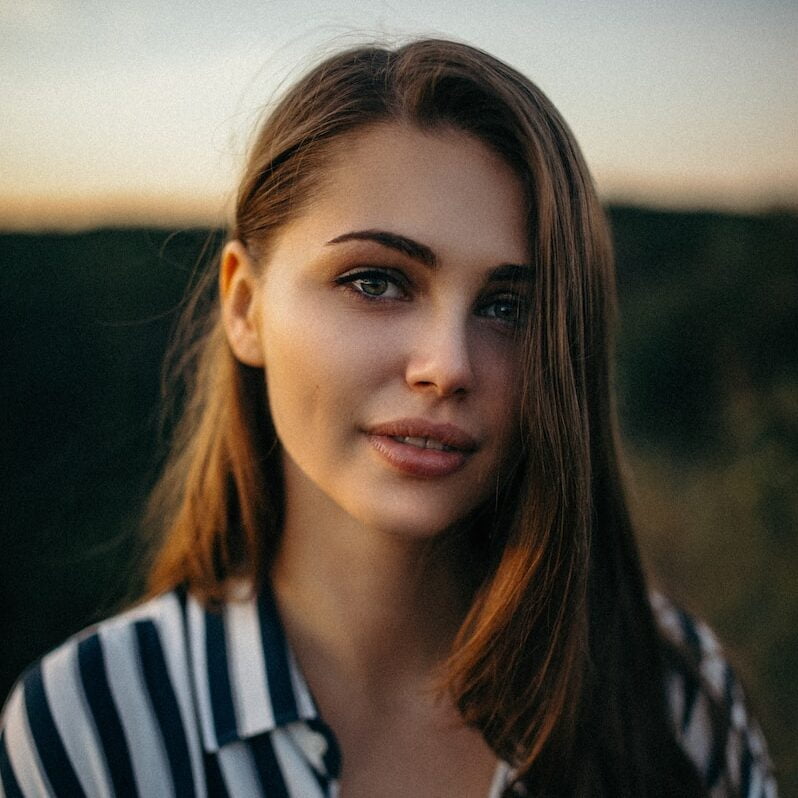 smiling woman wearing white and black pinstriped collared top