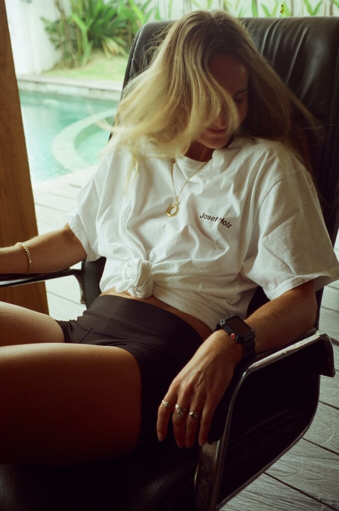 a woman sitting in a chair next to a pool