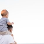 man in white shirt carrying boy